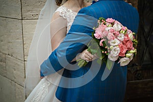 The bride holds a wedding bouquet in her hands, wedding day flowers