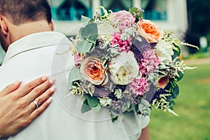 Bride hug groom with wedding bouquet