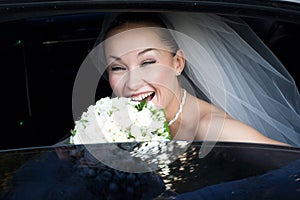 Bride laugh in the wedding car