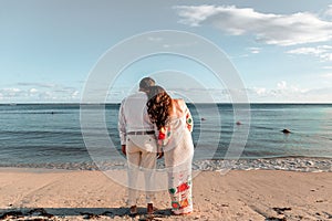 Bride leaning her head on the groom& x27;s shoulder on the sandy beach, the concept of love and eternity