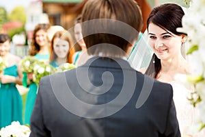 Bride looks charmed listening to the groom's oath