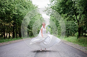 Bride looks funny whirling on the path in park