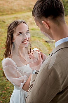 The bride looks at the groom with loving eyes. Smiling newlyweds look into each other& x27;s eyes.