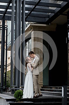 The bride looks at the groom with loving eyes. Smiling newlyweds look into each other& x27;s eyes.