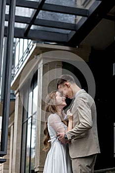 The bride looks at the groom with loving eyes. Smiling newlyweds look into each other& x27;s eyes.