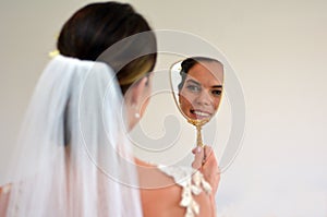 Bride looks at herself in the mirror on her Wedding Day