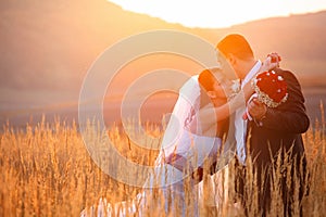 Bride looks up at a groom while he kisses her forehead delicately