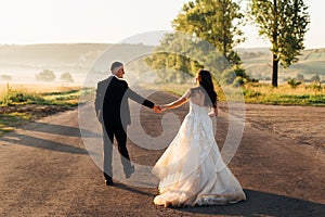 Bride in luxurious dress walks with a groom