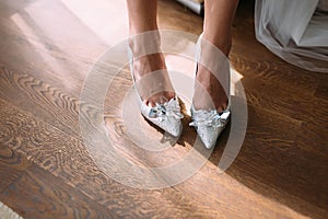 Bride in luxury wedding shoes with gems and rhinestones.