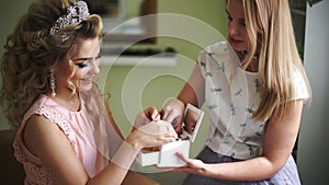 Bride with make-up artist chooses beautiful ornaments from the casket. Professional makeup for woman with healthy young