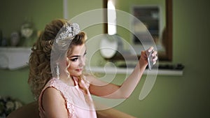 Bride makes selfie on phone. Stylish Woman Fiancee with Bridal Hairstyle, Event Makeup and Jewelry.