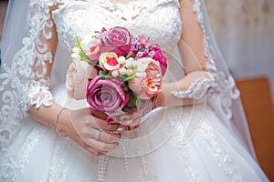 The bride holds a bouquet of white roses in her hands - Image. Bouquet in the hands of the bride - Image