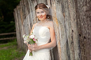 Bride near rustic fence close-up picture
