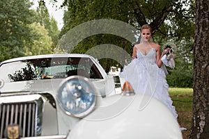 Bride near vintage retro car for wedding