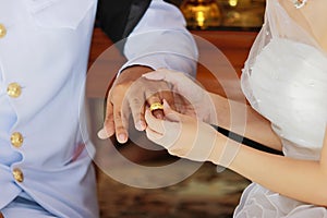 Bride newlyweds wearing ring on groom`s finger in wedding ceremony.