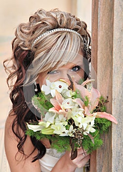 Bride peeking over flower bouquet