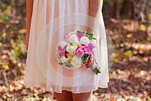 Bride in pink holding a bridal bouquet of flowers