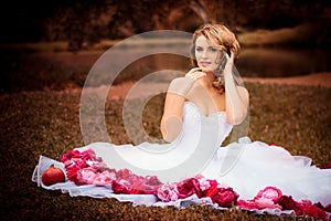 Bride portrait in white bridal veiling with artificial bunch photo session, leaves and trees background, summer weather, fashion