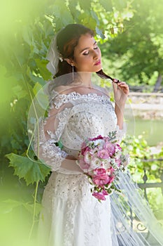 Bride posing in green foliage