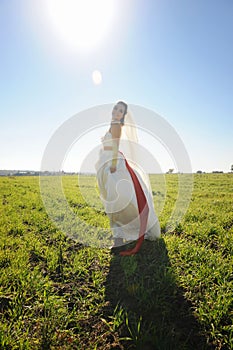 Bride posing outdoor on a green field