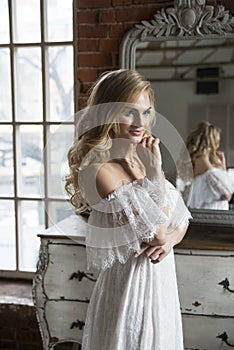 Bride posing reflecting in vintage mirror