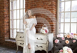 Bride posing sitting on vintage dresser