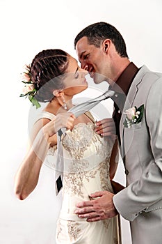 Bride pulling groom by his tie for kiss