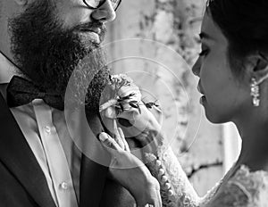 Bride Put on Small Flower Bouquet on Groom Tuxedo