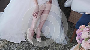 The bride puts on her shoes and puts her foot