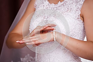 Bride puts on pearl bracelet.