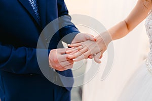 The bride puts the ring on the bridegroom at the wedding ceremon