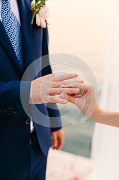 The bride puts the ring on the bridegroom at the wedding ceremon