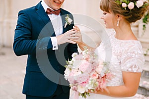 The bride puts a ring on the groom& x27;s finger and holds a bouquet in her hands during the wedding ceremony