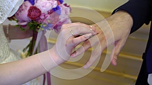 The bride puts a ring on the grooms finger at the wedding ceremony. Exchange of rings