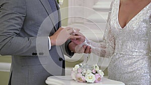The bride puts a ring on the grooms finger at the wedding ceremony. Exchange of rings