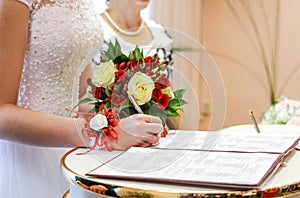 Bride puts signature in registry office.
