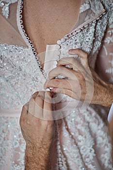 Bride puts on wedding dress on wedding day