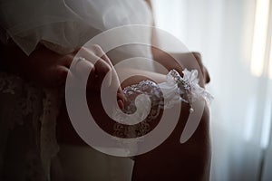 Bride puts on a wedding garter