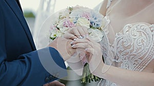 The bride puts the wedding ring on finger of the groom. marriage hands with rings. The bride and groom exchange wedding