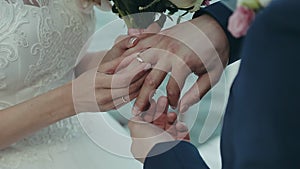 The bride puts the wedding ring on the groom`s finger. Wedding ceremony near the water. Marriage hands with rings close