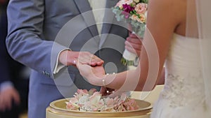 Bride puts on wedding ring on groom`s hand