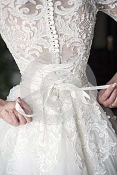 Bride putting on her white wedding dress