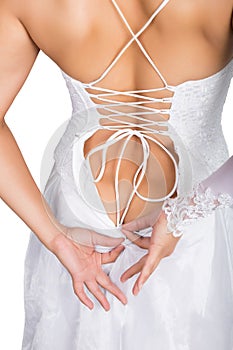 Bride putting on her white wedding dress, closeup hands and lace dress. young woman tying up her wedding dress