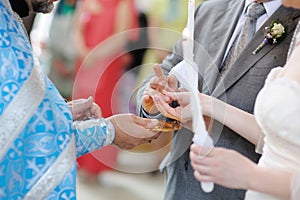 Bride putting a ring on groom's finger