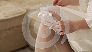 Bride is putting on a wedding garter