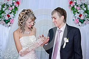 Bride putting a wedding ring on groom's finger