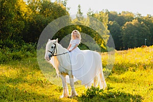 Bride riding a horse on the background of sunset