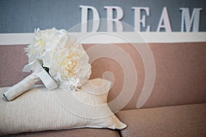 The bride`s bouquet on a couch. Dream text in the background.