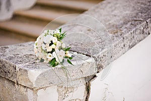 The bride s bouquet lies on an antique balustrade