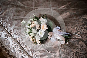 A bride`s bouquet lies on the bed